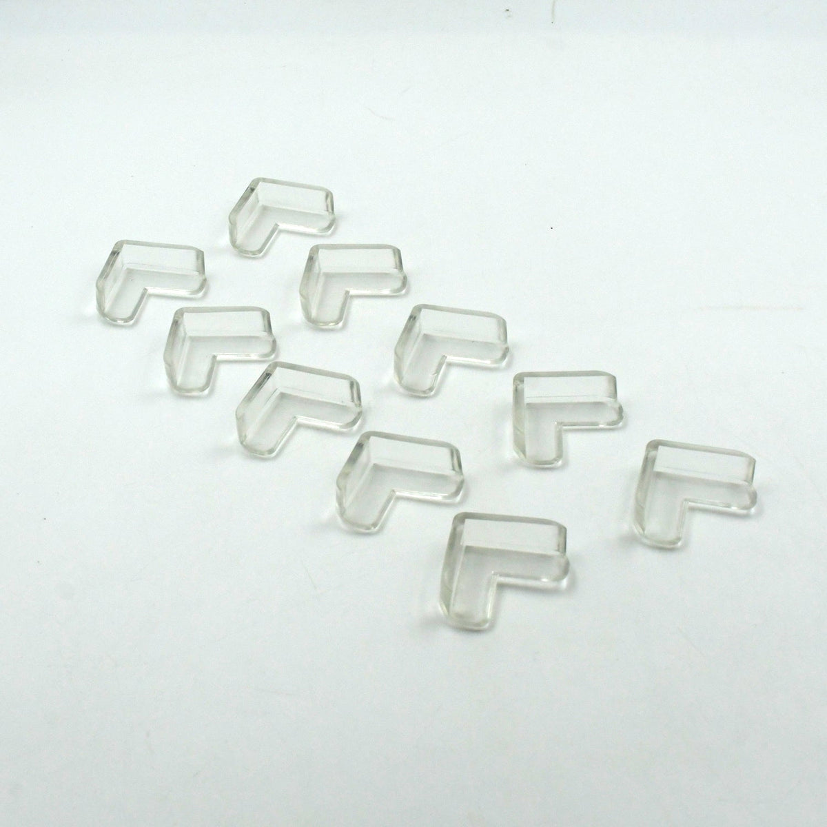 Multiple clear corner guards effectively applied to sharp furniture edges in a home.