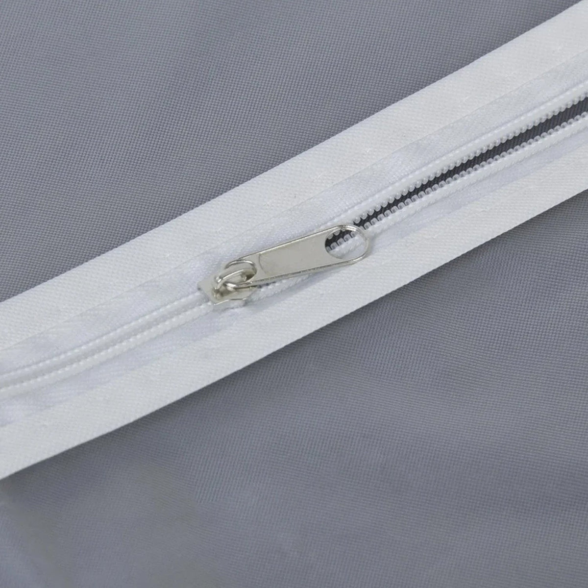 Closeup of full-length zipper on suit cover with breathable fabric.