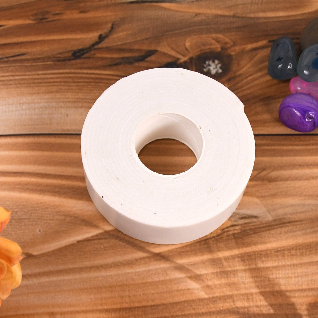Close-up view of double sided foam mounting tape applied to a smooth surface