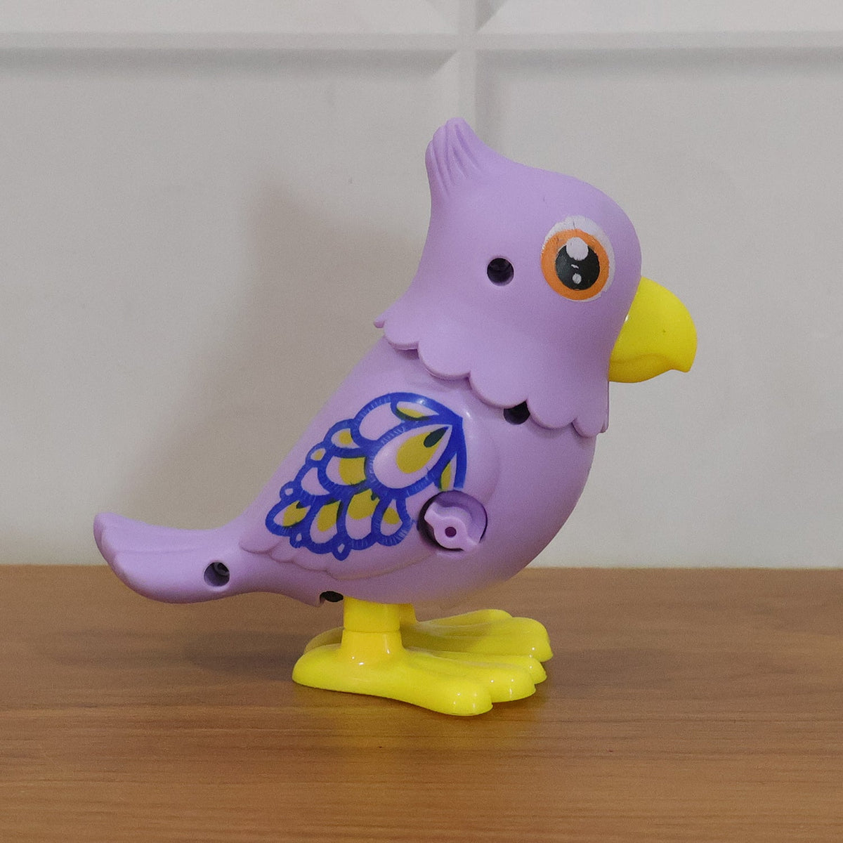 Playing with colorful wind-up bird toy for kids