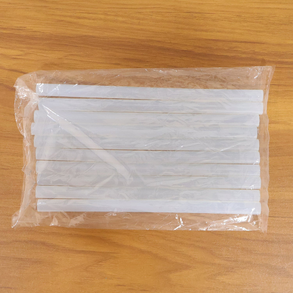 Hot glue sticking wood, fabric, and paper for craft projects