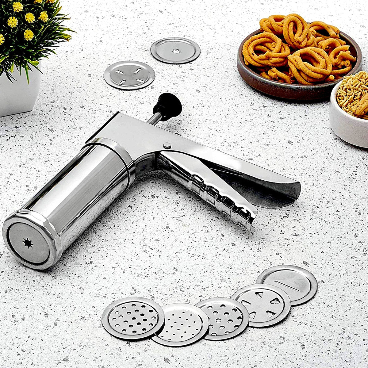 Stainless steel kitchen press with 15 interchangeable discs for making various Indian snacks.