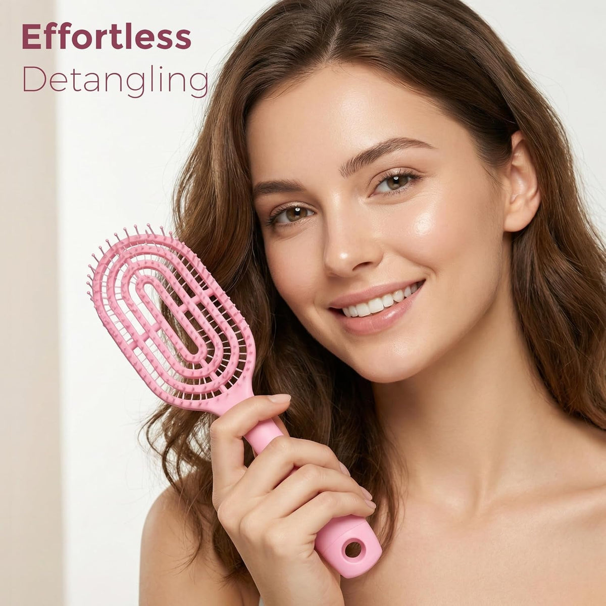 Person holding pink curved vented detangling hair brush while styling
