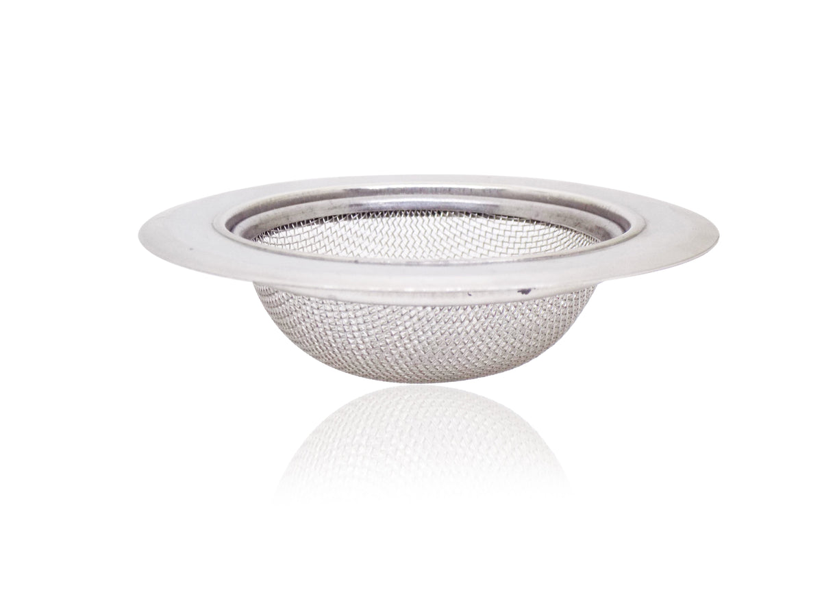 Stainless steel sink strainer effectively catching food particles in a kitchen wash basin drain.