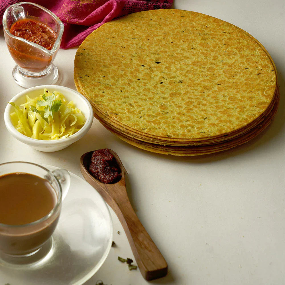 Maniarr's Masala Khakhra presented on a plate, surrounded by fresh spices, emphasizing natural ingredients.