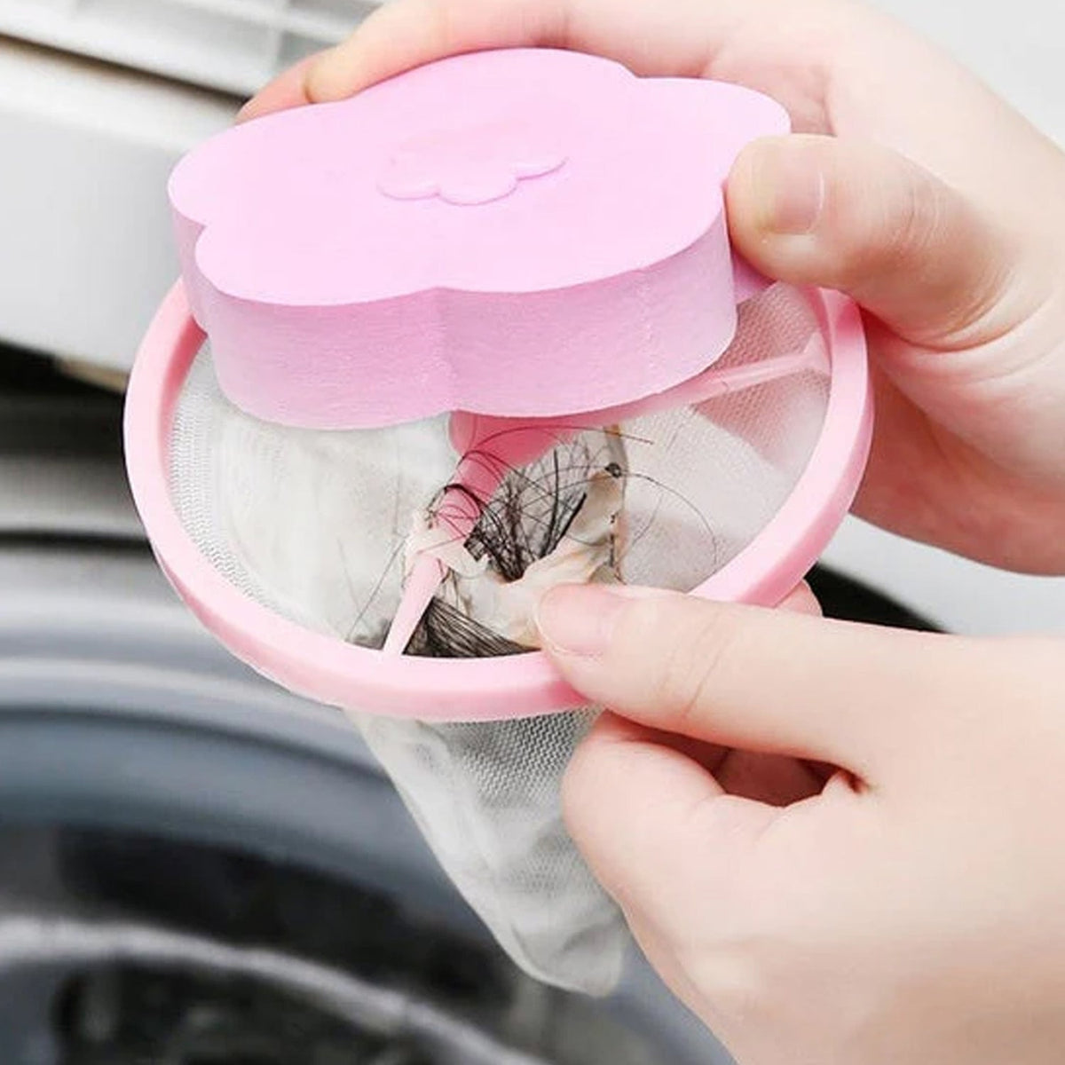 Hand holding flower-shaped lint remover showing collected lint